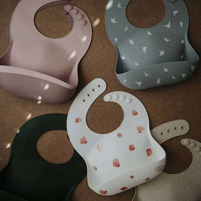 babete para bebés e crianças em silicone com bolsa colectora na cor tradewinds da marca mushie mais cores disponíveis