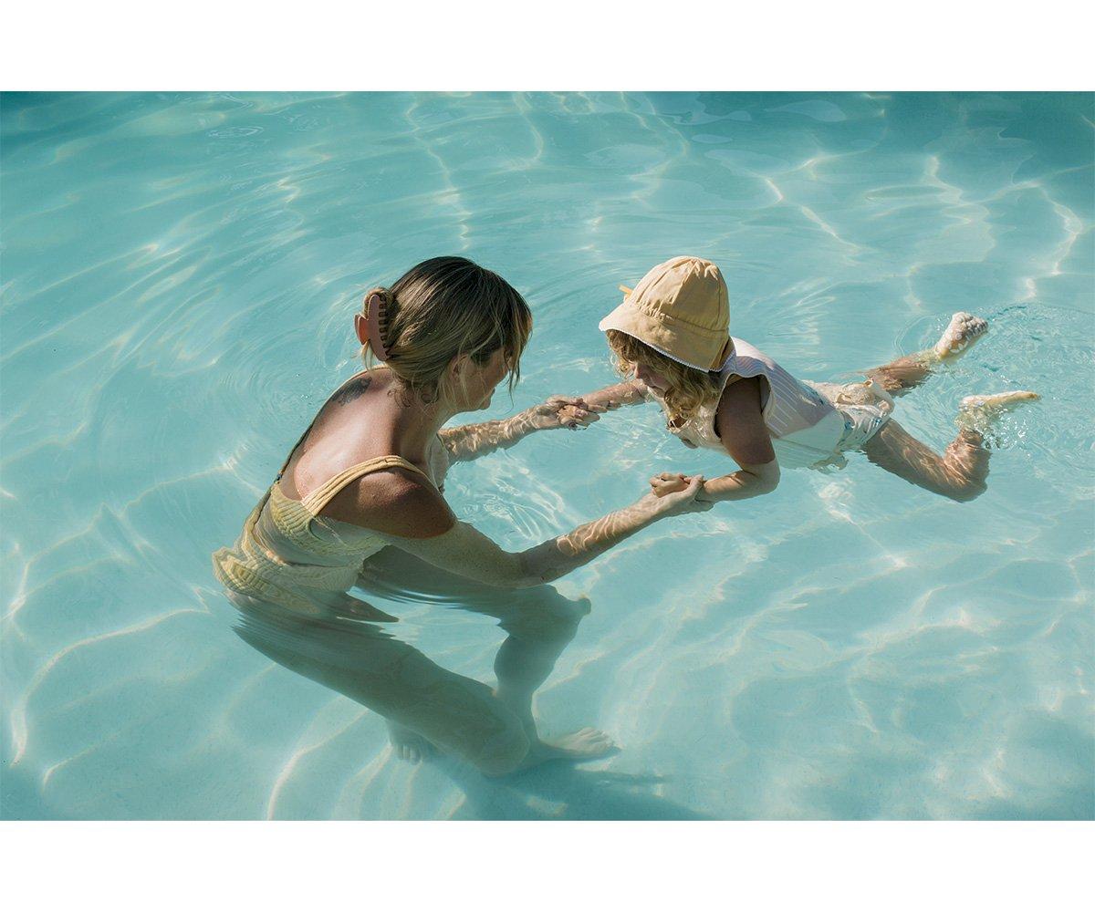 colete flutuador infantil da marca Monneka para bebés e crianças no padrão Surf Van na água