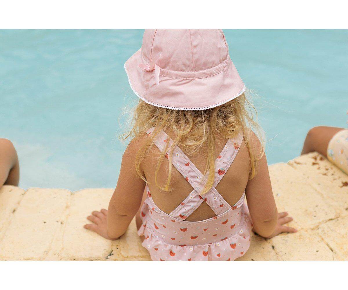 criança a usar o fato de banho infantil com folhos da marca monneka no padrão Strawberries vista aproximada
