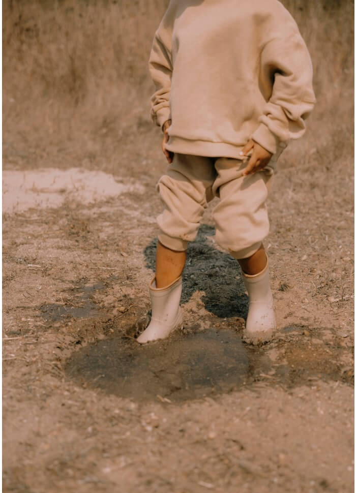 Botas infantis para a chuva na cor taupe da marca Mrs ertha (galochas) em poça de água