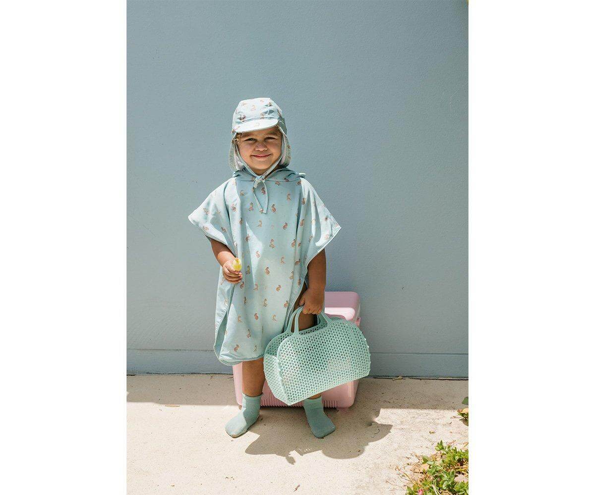 Poncho de praia infantil para bebés e crianças da marca Monneka no padrão cool dinos em uso