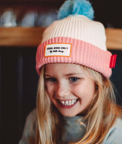 Menina loira a usar o gorro infantil para bebés e crianças da marca Mello hossy na cor pink ice