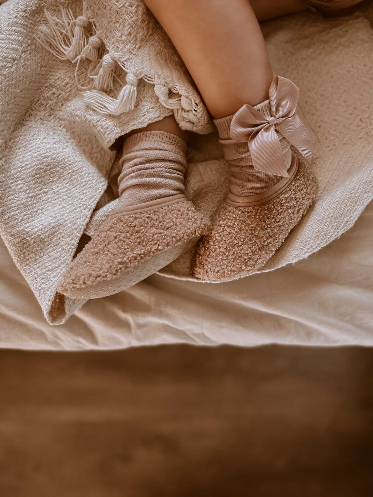 Pantufas infantis quentes e respeitadoras da marca Mrs ertha na cor peanut Detalhe em uso